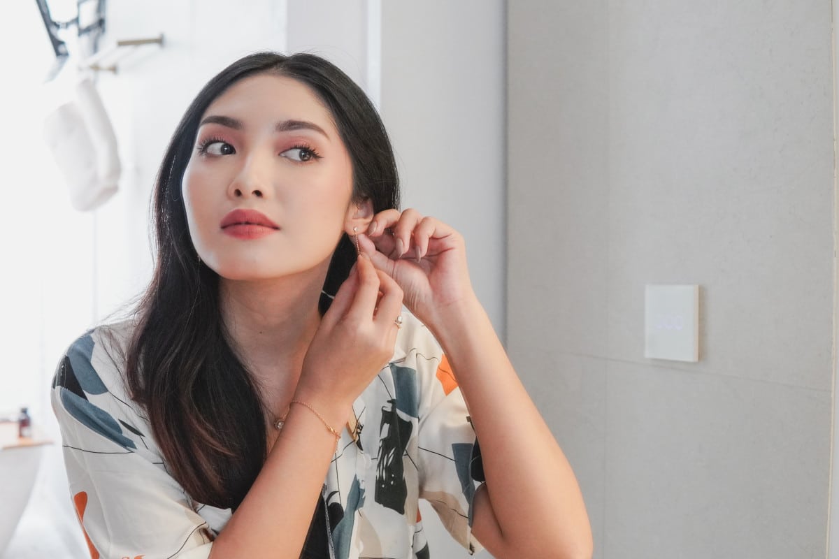 femme asiatique mets boucle d'oreille